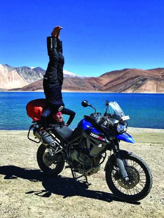 Sangeetha Jairam yoga headstand on a BMW GS